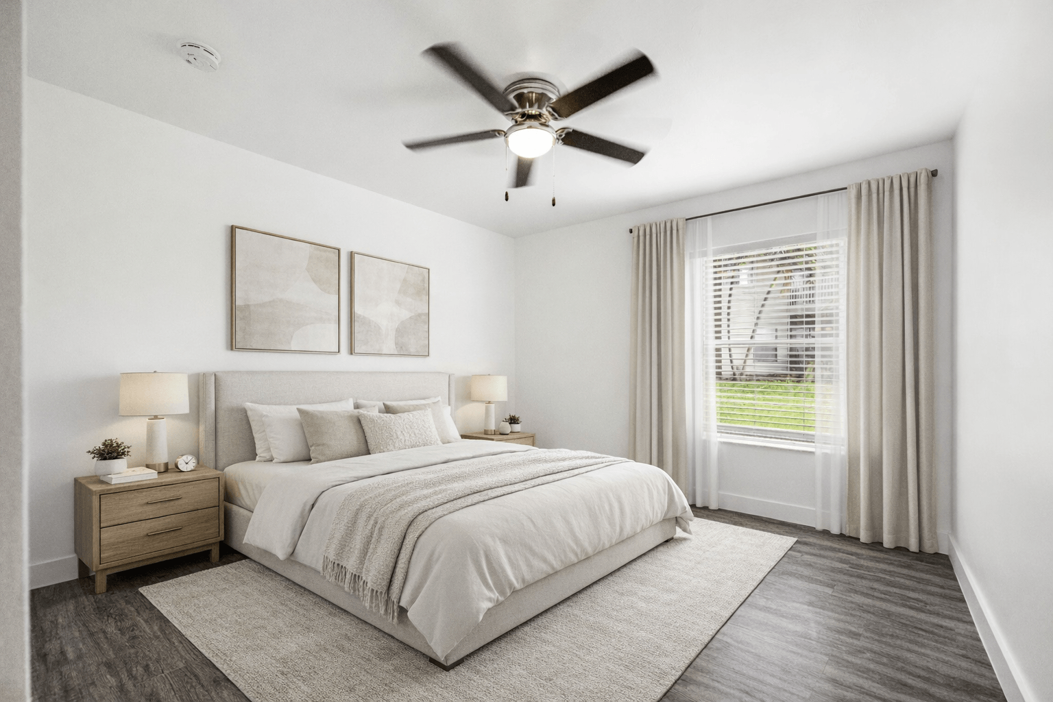 A bedroom with a large bed, a ceiling fan, and a window with curtains.